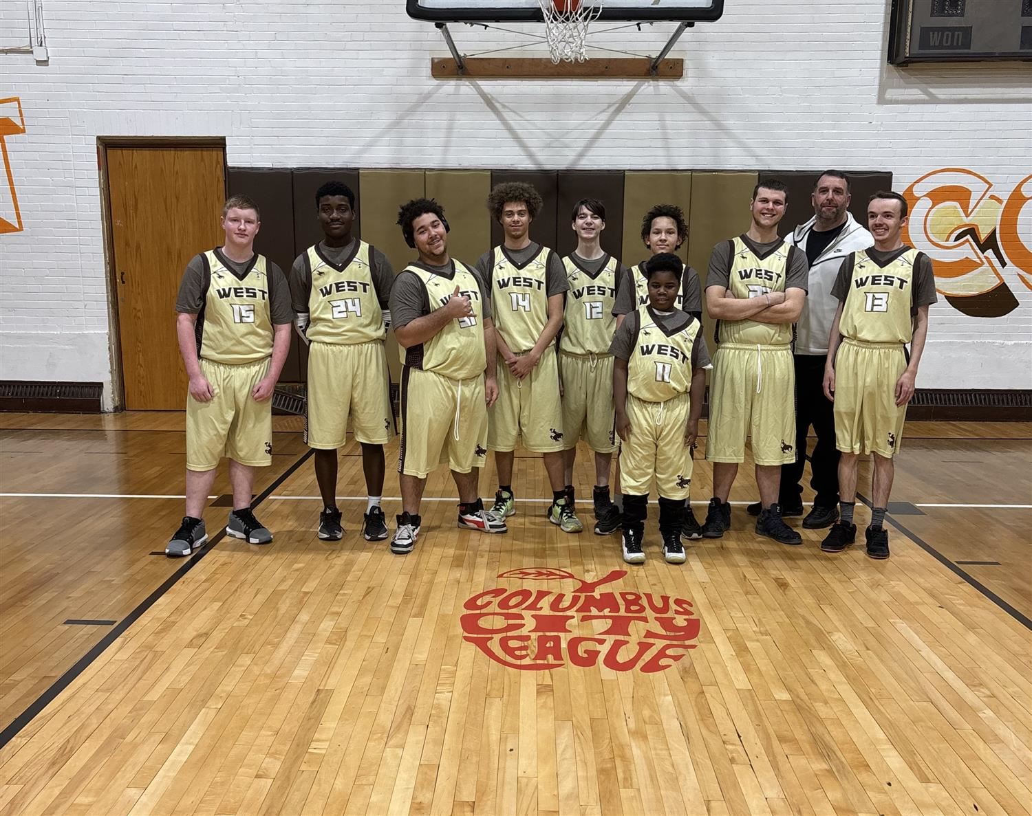 Basketball team posing by hoop