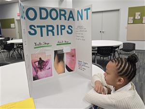 girl looking at project with pride