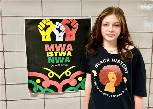 student standing in front of a sign