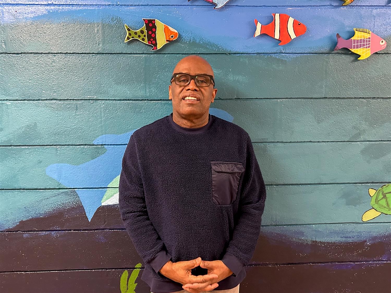 Conley posing in front of an ocean painted wall