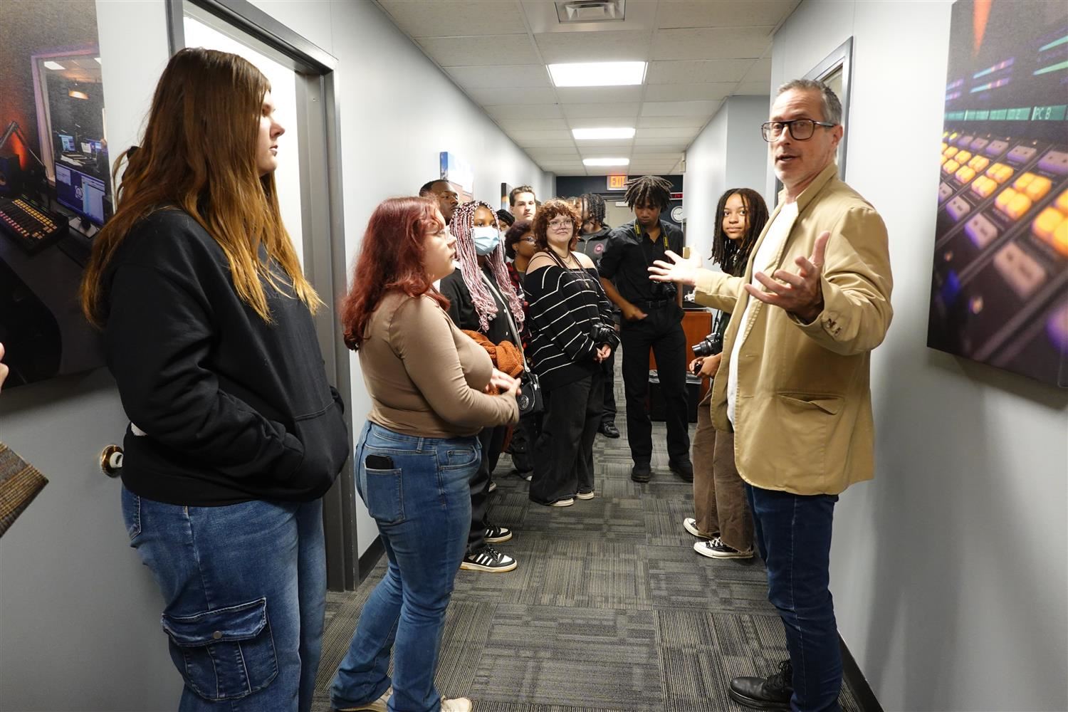 teacher standing with students in cramped hallway