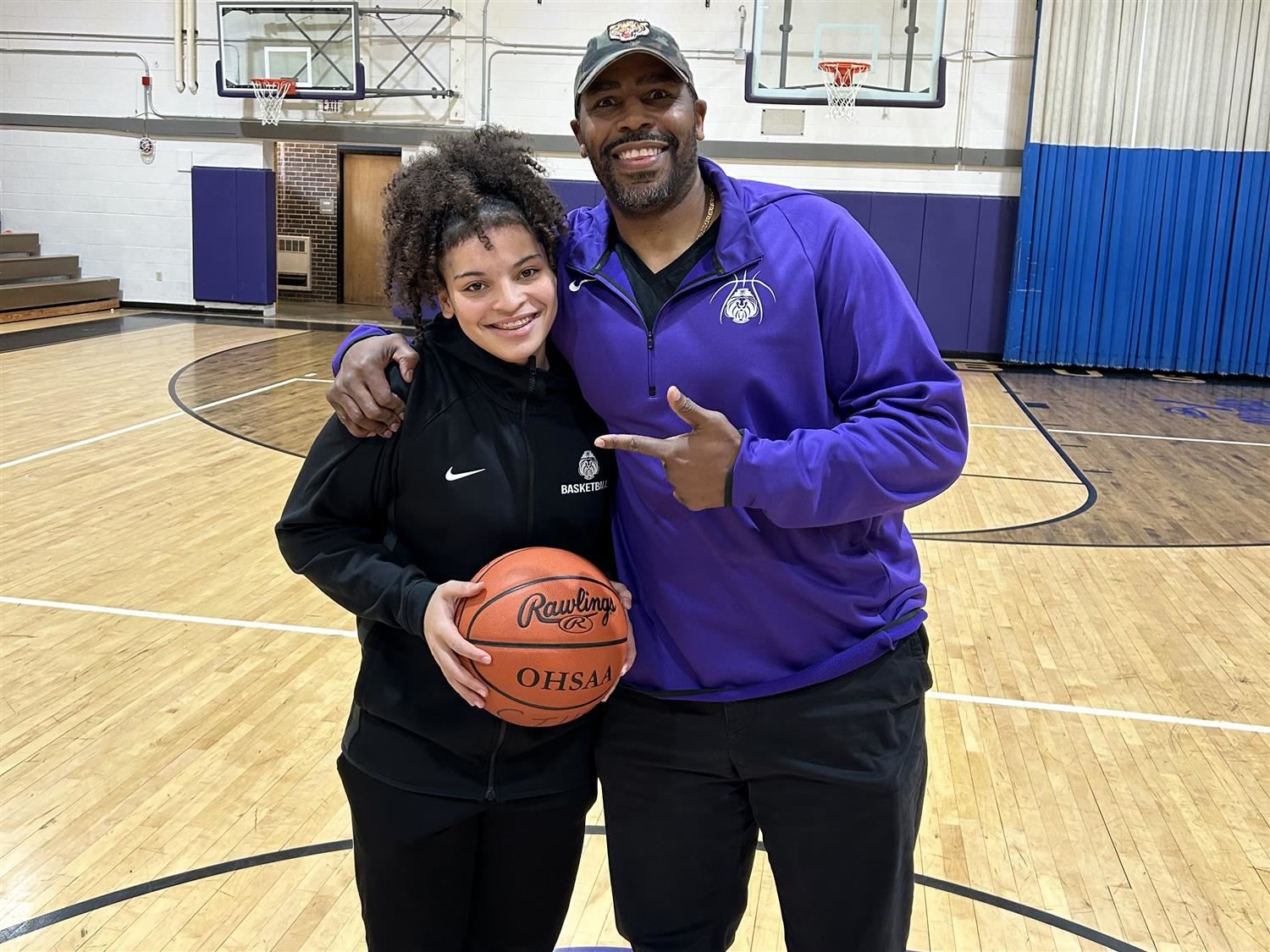 Leila Carter holding basketball with coach