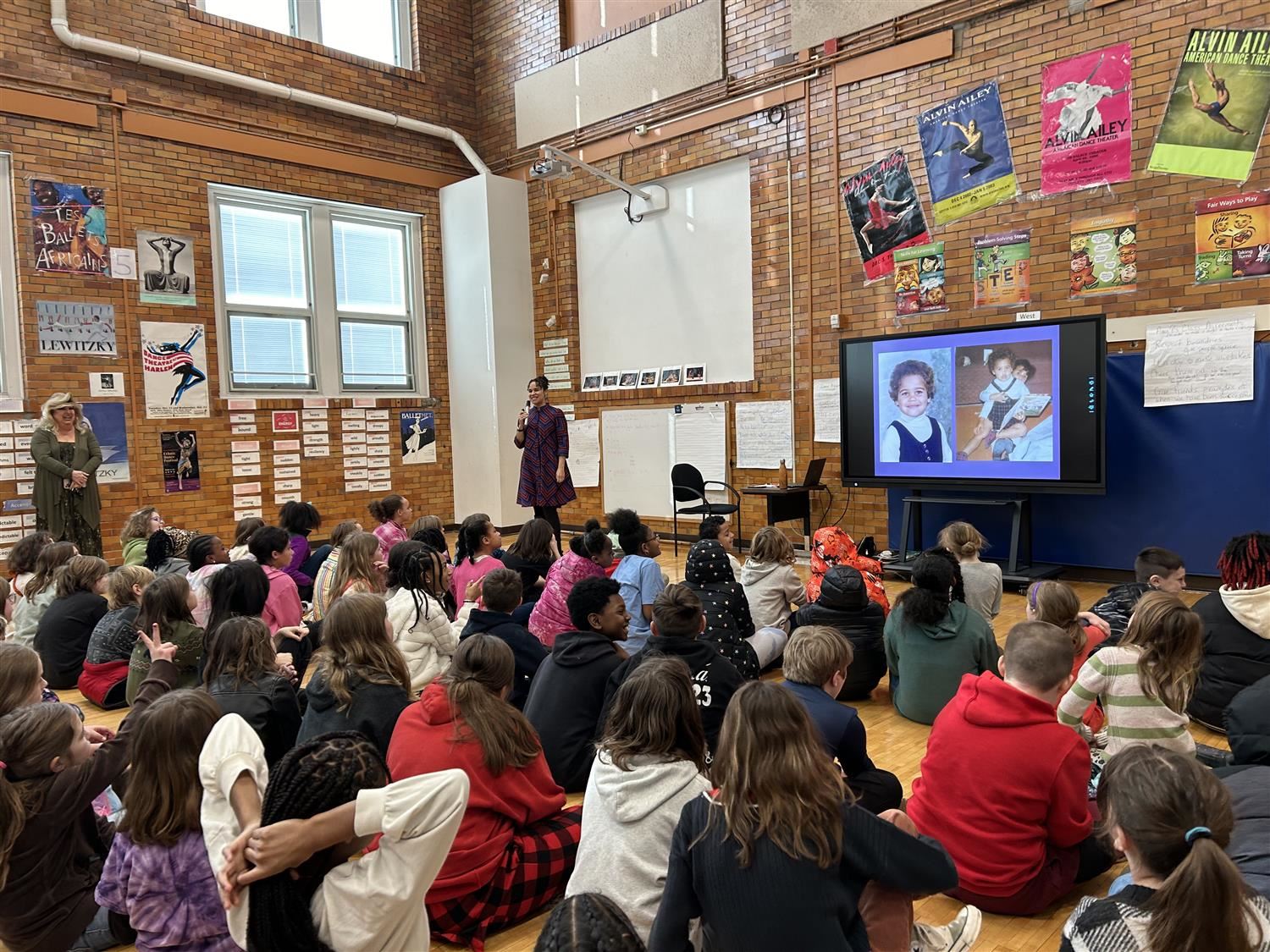 kids sitting on ground looking up at presenter