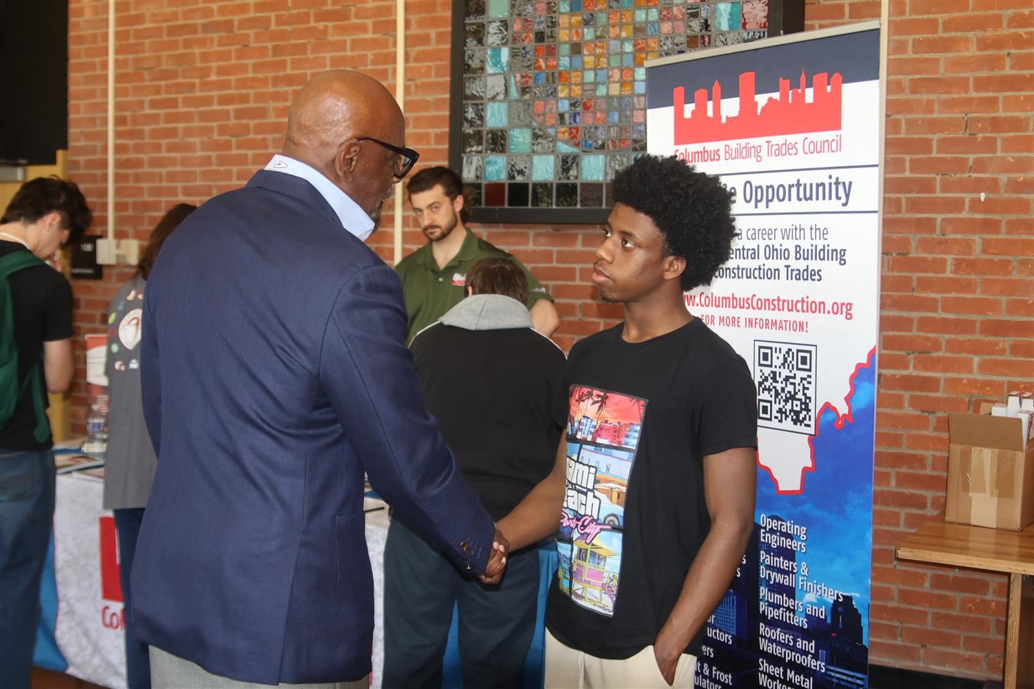 student shaking hands with chris gardner