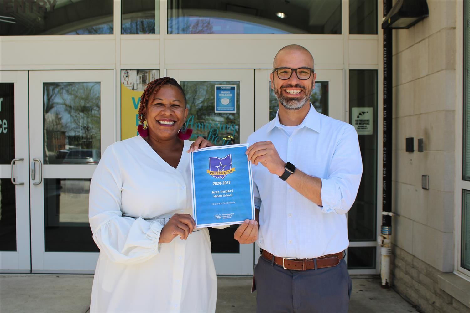 two people golding a blue sign