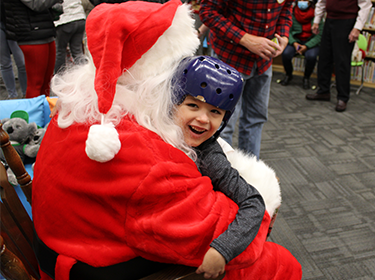  Image of young boy hugging Santa Claus