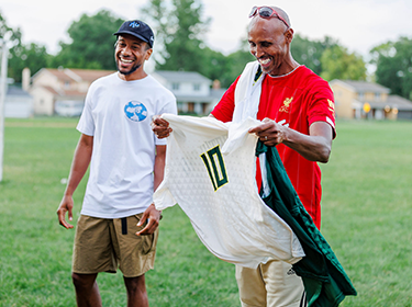  Coach Mahamoud Samantar’s Northland Boys Soccer Team smiles while holding new jersey