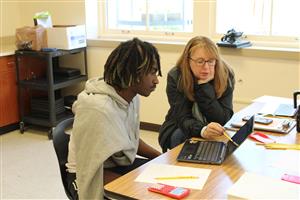 student and teacher at laptop
