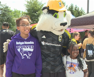 Student wearing a Northgate Wolves shirt with the Columbus Crew mascot standing next to him.